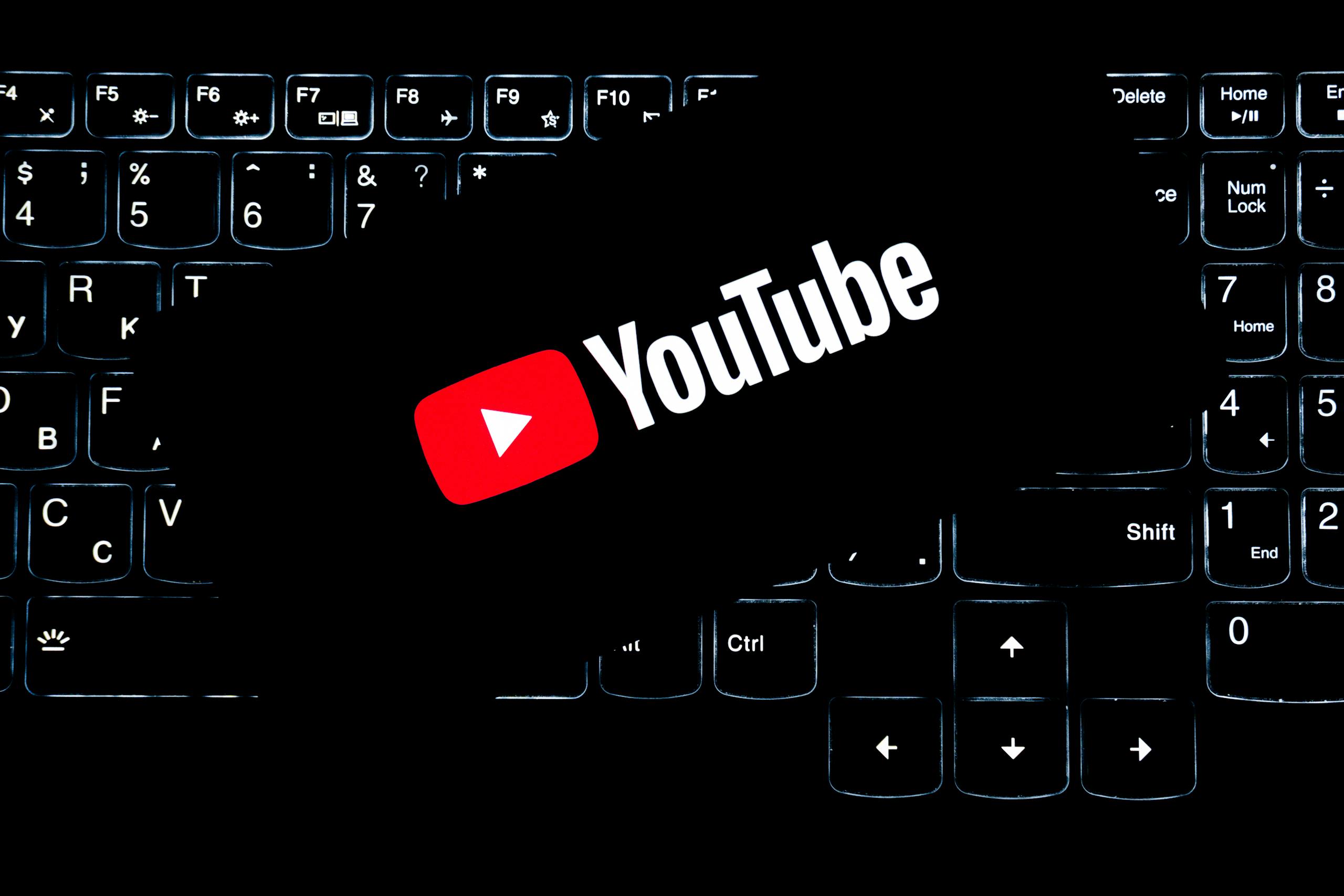 YouTube-Logo auf einer zurückbeleuchteten Tastatur, die digitale Medien und Online-Inhalte darstellt.